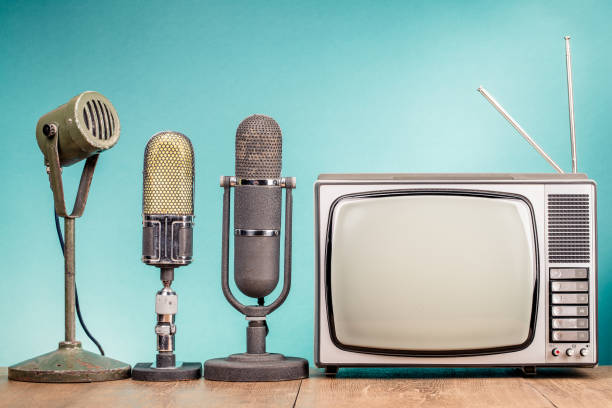 istock Retro old TV receiver and press conference microphones on table front gradient mint green wall background. Broadcasting concept. Vintage style filtered photo 1501760294
