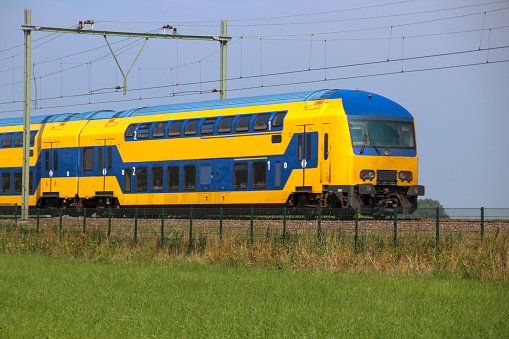 Double decker train on the track at Moordrecht heading to Gouda in the Netherlands