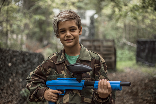 Portrait of a young male paintball team player