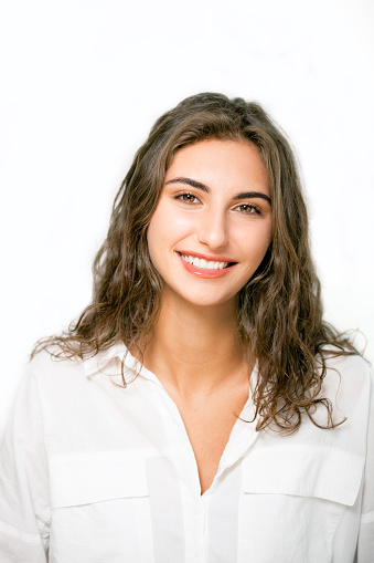 Portrait of beautiful happy young female brunette against white background.