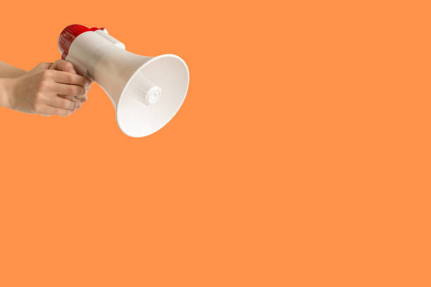 istock Megaphone in woman hands on an orange background. 1501765293