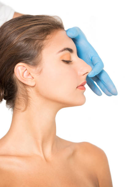 istock Cosmetician hand examining woman's nose. 1501765438
