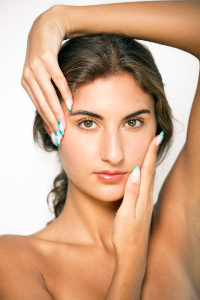 istock Confident woman touching face with painted fingernails. 1501765529