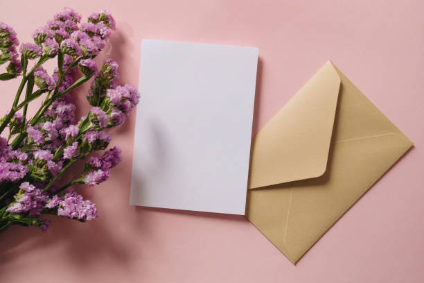 istock White blank greeting or invitation card and envelope with flowers decoration on pink background. Mock up presentation. 1501765589