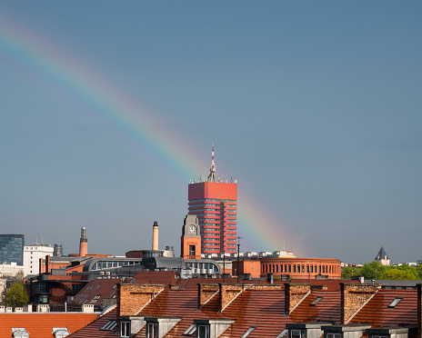 Cityscape and rainbow. View of the rooftops of city buildings after rain. Poznan