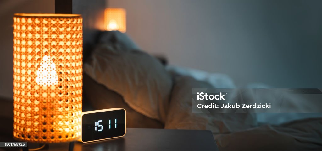 Smart clock bedroom Smart home devices. Alarm clock on the bedside table. Interior of the bedroom. Night lights connected to the home automation system. Copy space. Horizontal banner. Alarm Clock Stock Photo