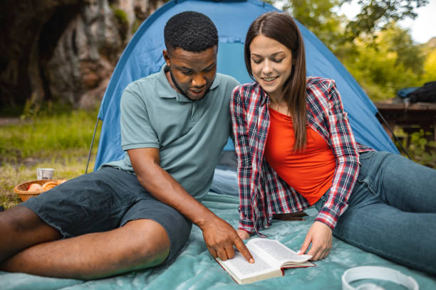 istock Couple camping, reading book together 1501767224