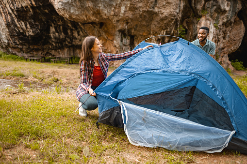 Young couple preparing tent for a mini vacation