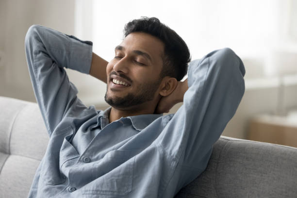 istock Happy relaxed handsome Indian guy sitting on comfortable sofa 1501769966