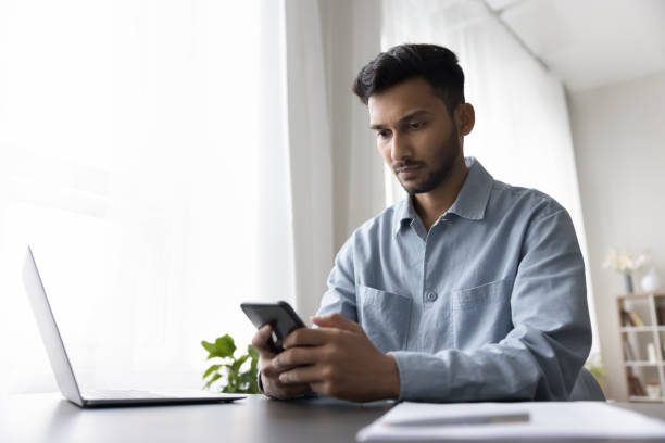 istock Focused serious young Indian business man using Internet technology 1501770009