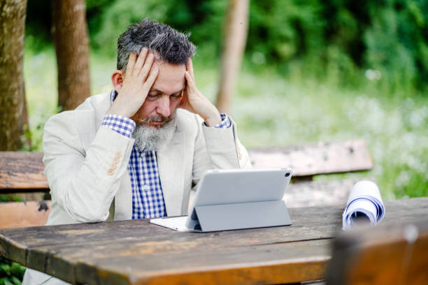 istock Stressed senior entrepreneur having a headache while working in nature 1501770130