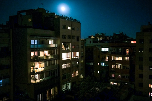 Windows and balconies illuminated at night in a residential area in Barcelona