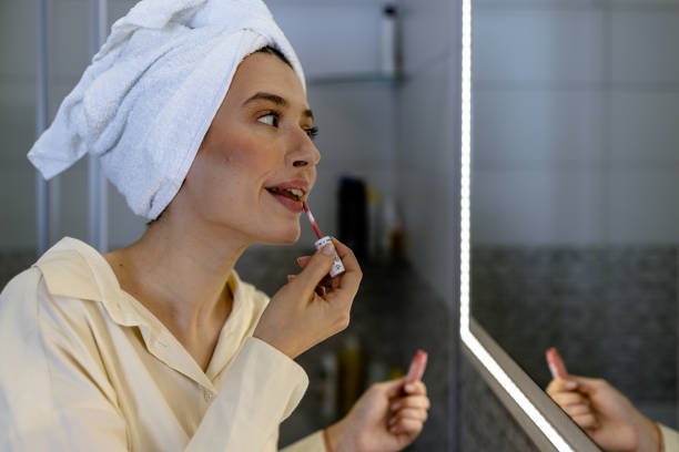 istock A young woman is applying lipstick at home. 1501773955