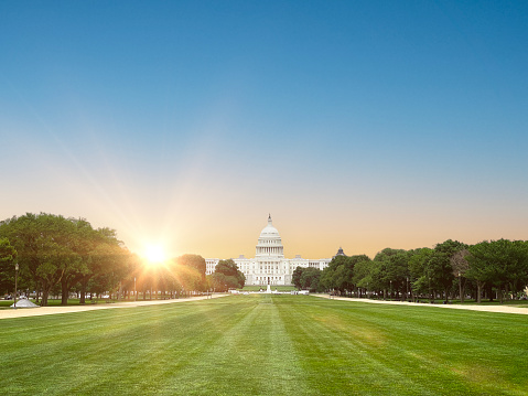 Wide angle shot of National mall park and United States Capitol building with sunrise