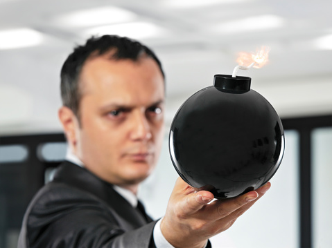 Businessman holding a bomb in an office