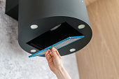 Woman removing air filter from cooker hood for cleaning