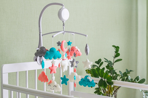 Baby crib mobile. Toys above the baby crib. Hanging soft clouds, stars and moon for the child.