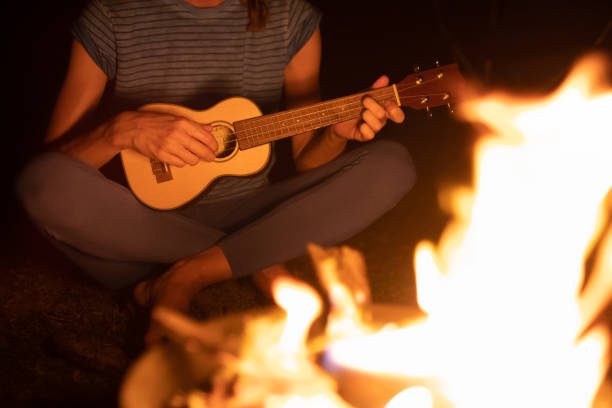 istock Woman playing ukulele during camping. 1501785633