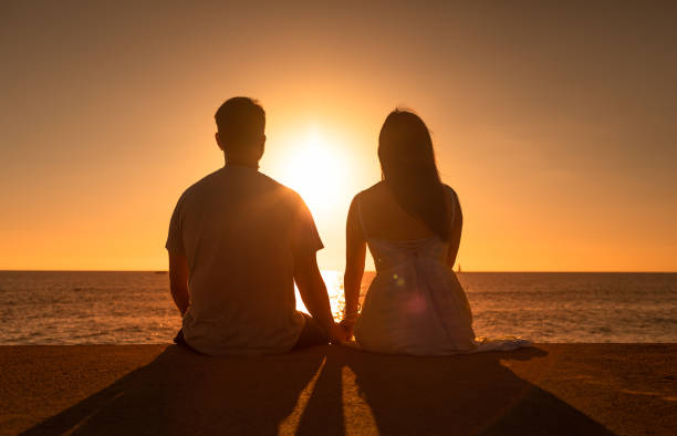istock Young couple holding hands watching the sun go down. 1501785652