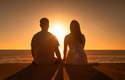 Young couple enjoying beautiful sunset.