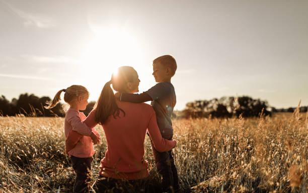 Felice momento madre, figlio e figlia trascorrendo del tempo insieme all'aperto nella natura. - foto stock