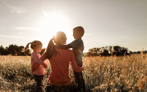 Happy mother, son and daughter moment spending time together outdoors in nature. stock photo