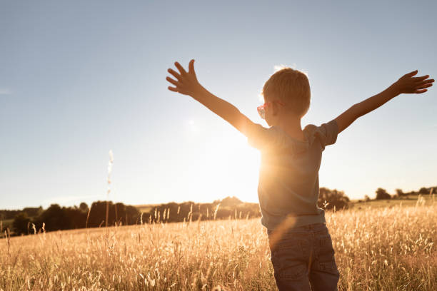 istock Child standing with arms up feeling free, hope and happiness 1501785991