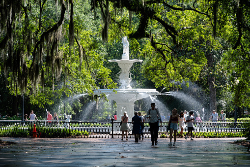 Savannah, Georgia - April 14, 2023: Spanning more than 30 acres, Forsyth Park is Savannah's largest and oldest public park. People are enjoying the park and fountain on a summer day.