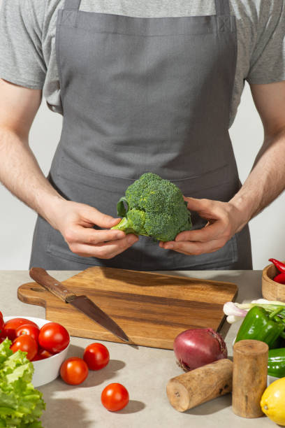 istock A man prepares a vegetable salad with a whole apron, close-up 1501791152