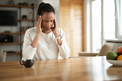 Young black woman having a headache at home