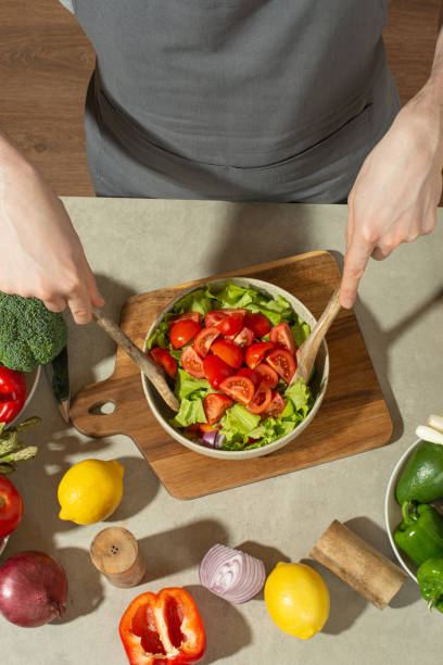 istock A man prepares a vegetable salad with a whole apron, close-up 1501792627