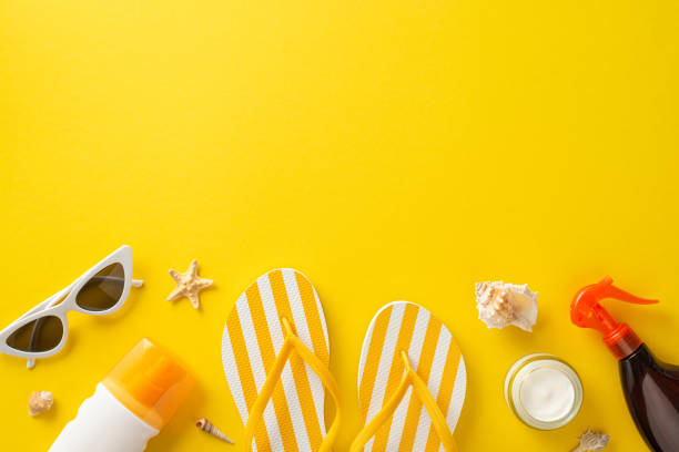 istock Vibrant yellow top view composition featuring sun protection essentials: unbranded sunblock oil and SPF cream bottles, trendy sunglasses, stylish flip-flops, shells, starfish with space for text or ad 1501792774