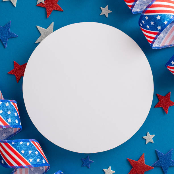 istock USA's Independence Day-inspired setting. Square top view perspective of emblematic party paraphernalia, serpentine and sparkling stars, against a blue background with an empty circle for text 1501792940