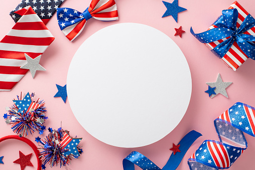 Ignite the festive spirit of Independence Day with enchanting top view arrangement: serpentine, stars, confetti, headband, bow-tie, necktie, giftbox on pastel pink, featuring circle for text or promo