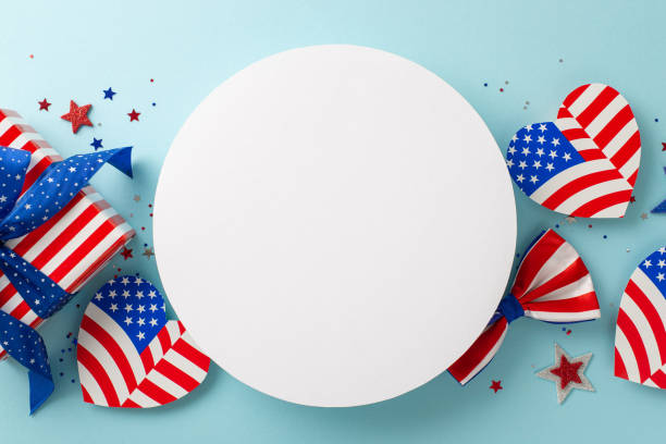 istock Flag Day celebration. Top view showcasing symbolic elements: hearts with American flag pattern, confetti, giftbox wrapped in thematic paper, bow-tie, light blue backdrop with circle for text or ad 1501793018