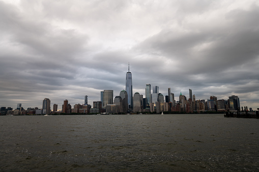 Jersey City, NJ, USA - June 6, 2023: The lower Manhattan skyline as seen from Exchange Place in Jersey City, NJ on a cloudy day.