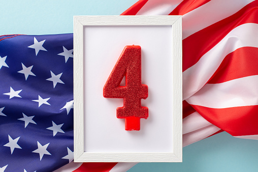 The fourth of july celebration concept. Above view photo empty rectangular wooden frame with shiny number four surrounded by an american flag on celeste isolated background