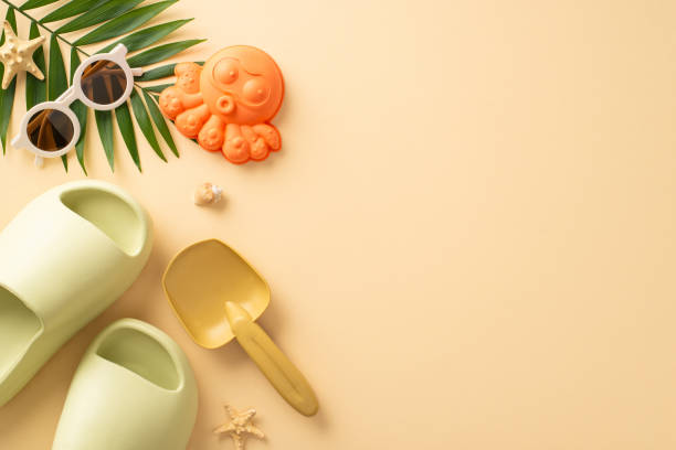 istock Peaceful beach vacation with infant. Top view composition showcasing playthings, sandcastle accessories, shades, comfy slippers, shell, starfish, palm leaf, calming beige surface. Great for text or ad 1501798233
