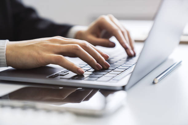 istock In the blurred setting of an office, a close-up shot captures a woman's hands typing on a modern laptop keyboard 1501805000