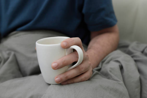 istock man holding large mug on bed 1501808787