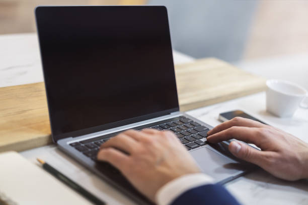 istock The image captures a man's hands typing on a modern laptop keyboard, with the office setting in the background appearing blurred 1501809372
