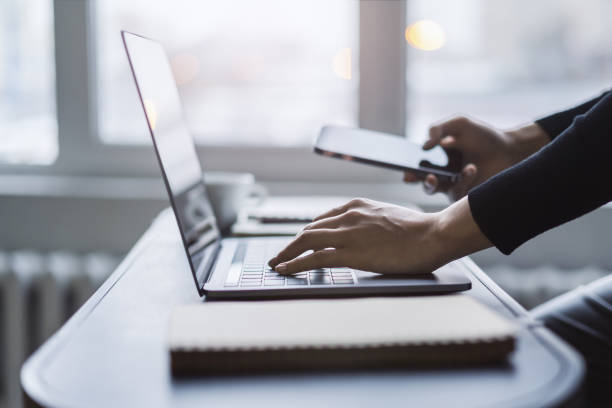 istock Woman's hands captured in close-up, typing on a modern laptop amidst a hazy office background 1501812898