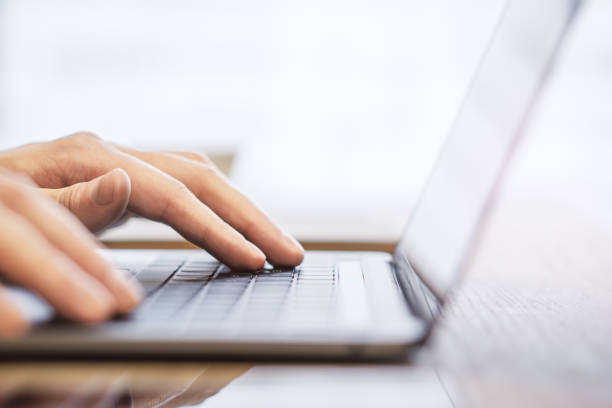 istock Against a blurry office backdrop, a close-up view reveals a man's hands as they type on a sleek laptop keyboard 1501813953