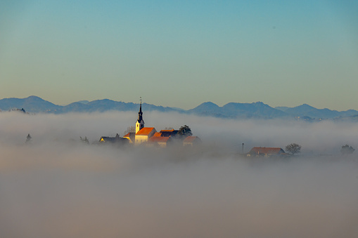 Aerial view of Church amidst clouds with mountain in background