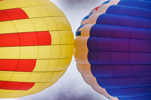 Red hot air balloon in blue sky with white clouds