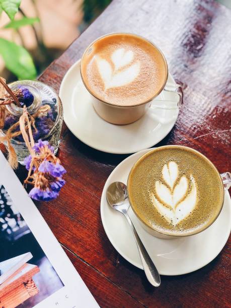 istock High-angle view of two white coffee cups, each with intricate coffee art designs on the surface 1501831926