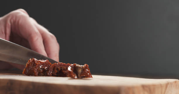 istock closeup man slicing sundried tomatoes 1501839070