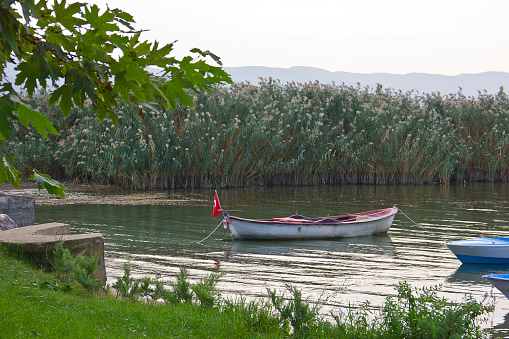 People are resting near the Lake of Iznik in Turkey and there are people on fishing boats is in the small harbour of Iznik, bursa, turkey.
