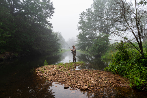 A man fishing for perch and bass in a creek in Oklahoma.