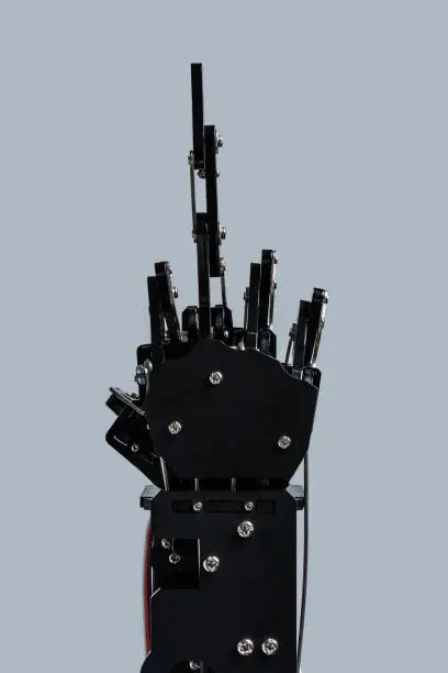 Real robotic hand giving the middle-finger against grey background. Concepts of AI takeover and Technological singularity.
